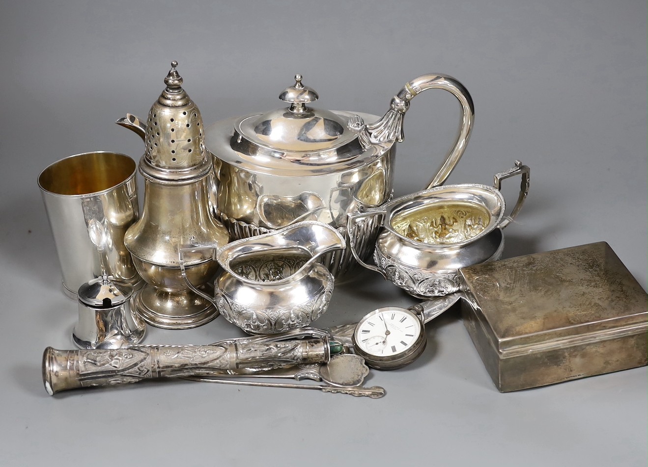 An Indian white metal cream and sugar bowl by Krishnian Chetty of Bangalore, a modern silver beaker by The Marlow Brothers, a sterling sugar caster, silver cigarette box, Chinese white metal teapot and nine other items.